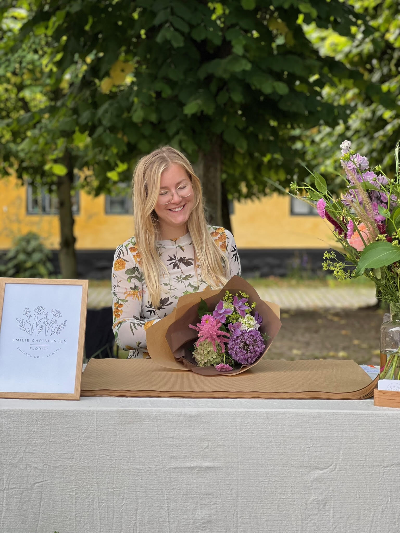 Emilie Christensen, der binder en frisk blomsterbuket ved sin stand